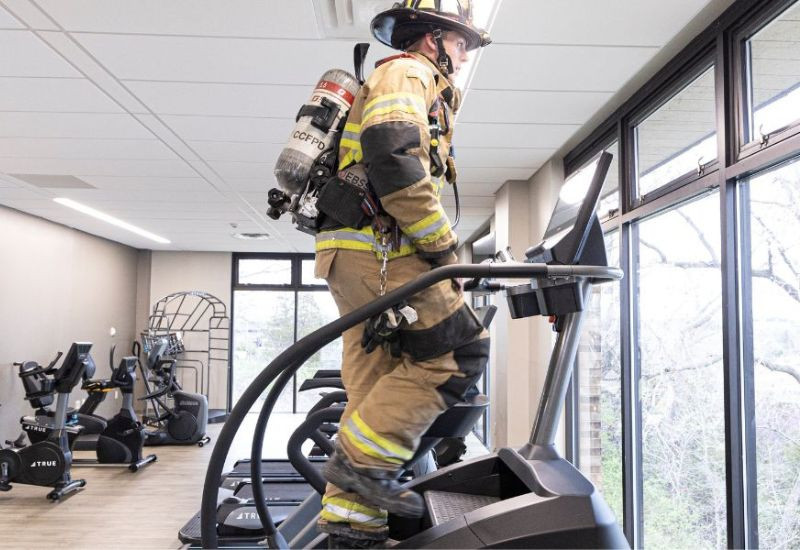 Fire man in full gear on a step climber machine
